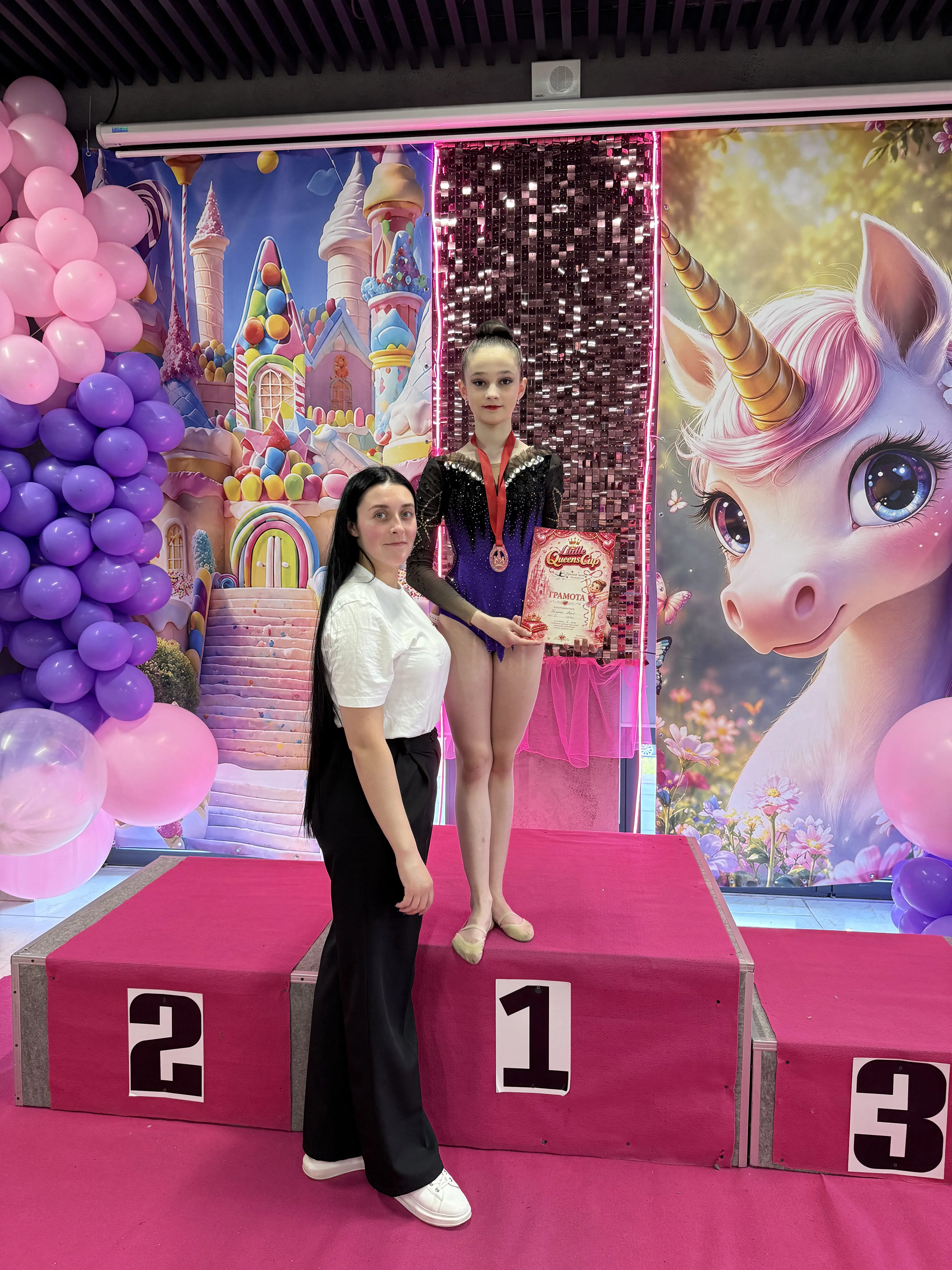 Фото гімнастки команди Estela з тренером після виступу на змаганнях 'Little Queens Cup 2026'