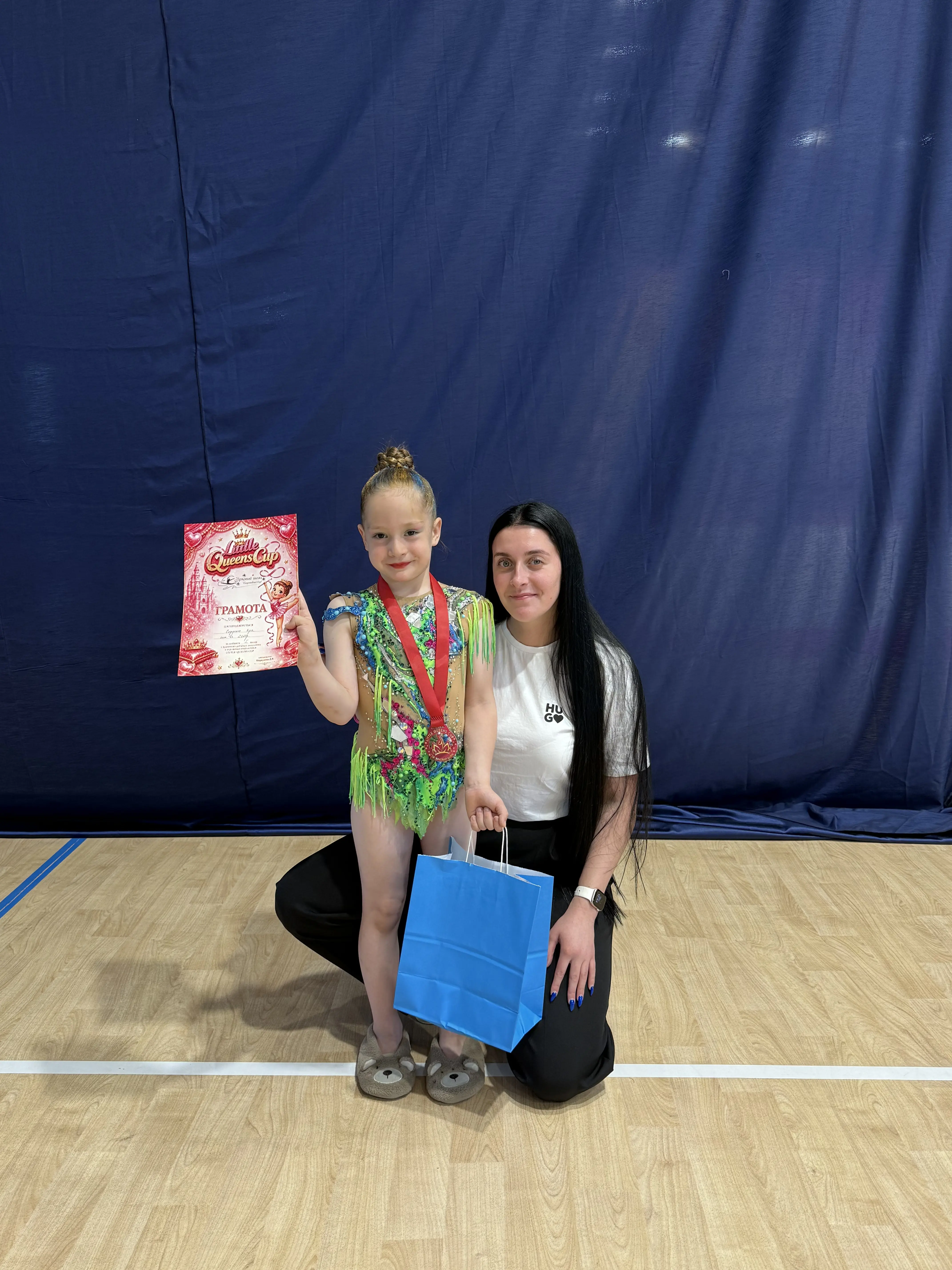 Задоволена гімнастка команди Estela на першому місці у турнірі 'Little Queens Cup 2026', з художньої гімнастики